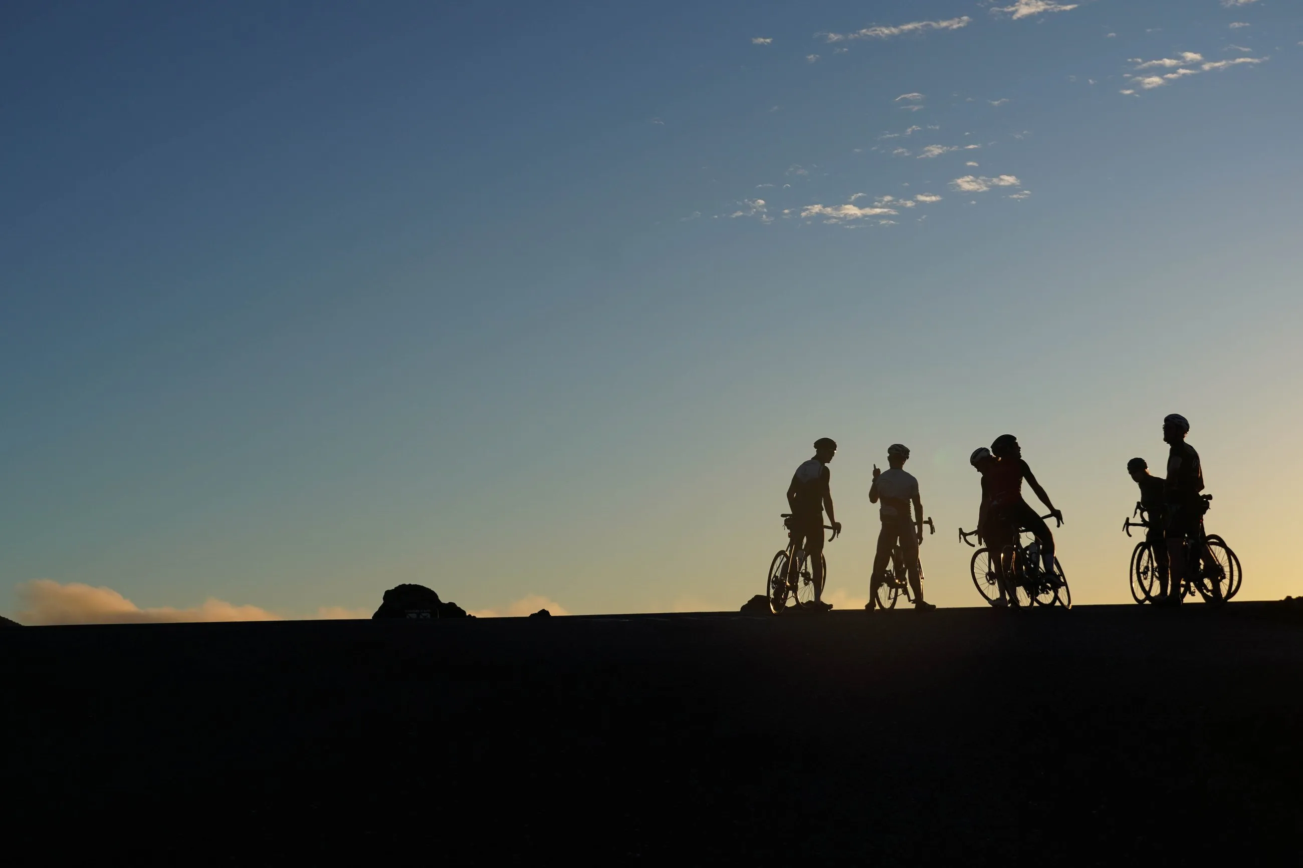 Fietsers in silhouet tegen een avondlucht